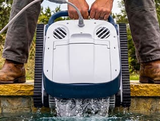 Pool owner relaxing by a clean pool thanks to a Dolphin robotic cleaner