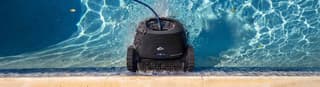 Dolphin robotic pool cleaner scrubbing the waterline of a backyard pool